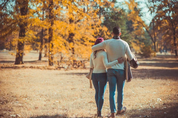 一个男人在公园里拥抱他的女朋友 一边走在秋黄叶上 享受大自然 — 图库照片