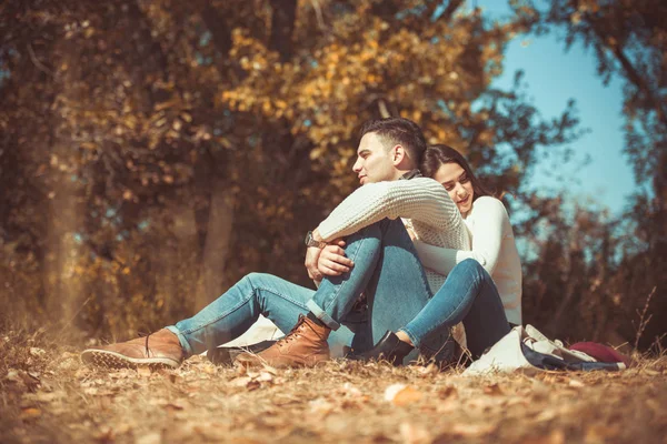 Sweet couple is outdoors, they are looking very happy while  hugging in the autumn park