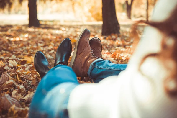 세련된 부부는 자신의 부츠를 보여주는 공원에 누워있다 — 스톡 사진
