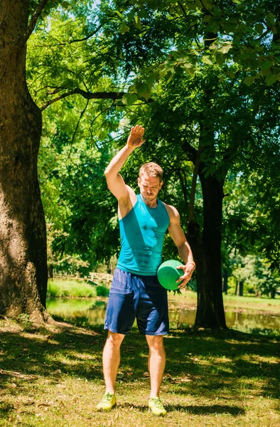 筋肉の男が公園で医学ボールのエクササイズ — ストック写真