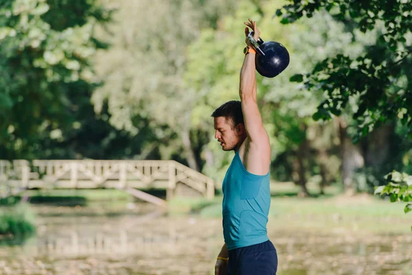 Συμπυκνωμένο Νεαρό Αθλητή Κρατώντας Kettlebell Βαρέων Μετάλλων — Φωτογραφία Αρχείου