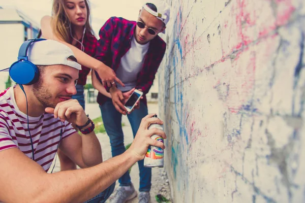 Tres Jóvenes Amigos Divierten Dibujando Graffiti Pared Con Spray — Foto de Stock