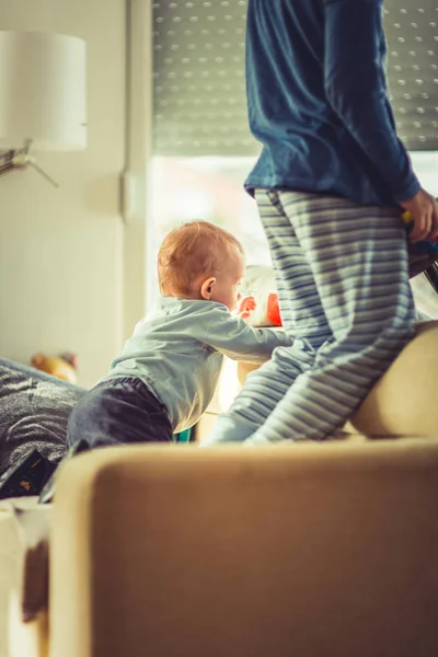 Egy Gyönyörű Kisfiú Áll Kanapén Játszik Bátyjával — Stock Fotó