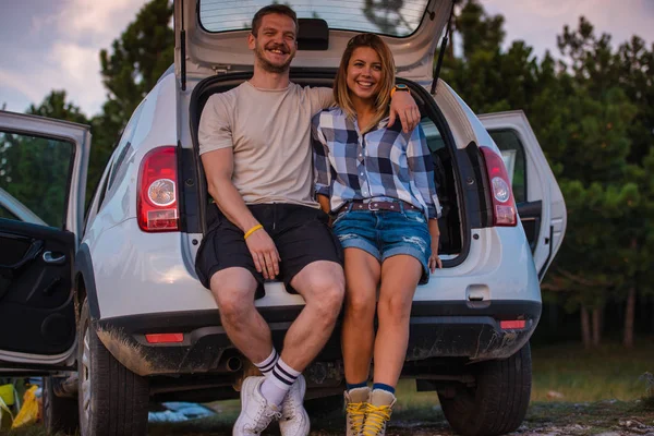 一对年轻夫妇坐在一辆越野车的后座上 日落时坐在车内欣赏风景 — 图库照片