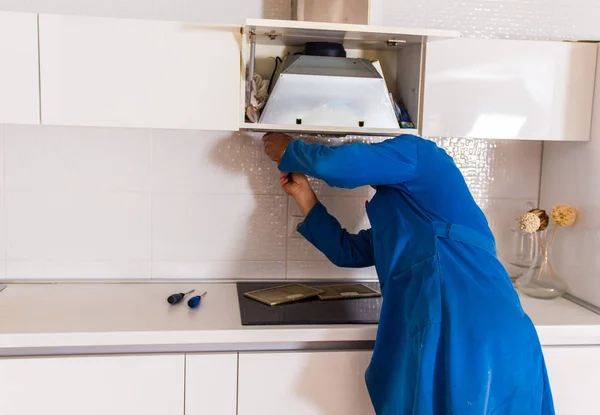 Ein Handwerker Blauen Arbeitsanzug Repariert Die Lüftung Der Küche — Stockfoto