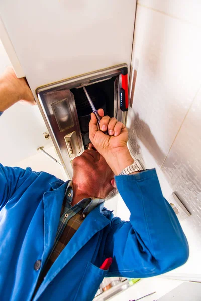 Ein Handwerker Blauen Anzug Repariert Den Küchenventilator Mit Einem Schraubenzieher — Stockfoto