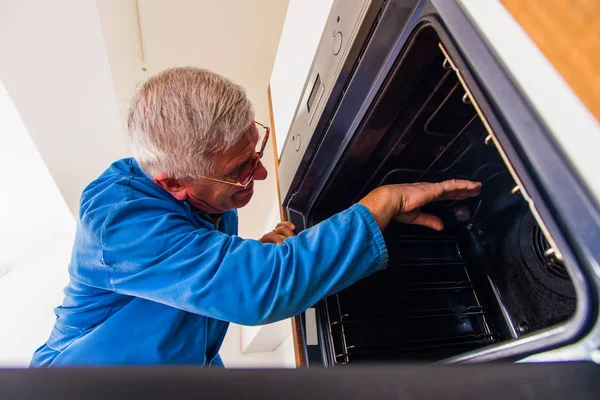 Παλιά Είναι Επισκευαστής Συνεργάζεται Χέρια Του Στο Φούρνο — Φωτογραφία Αρχείου