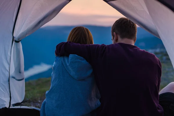 夕日に山の上でたき火をして山の景色を楽しむ若いカップル — ストック写真