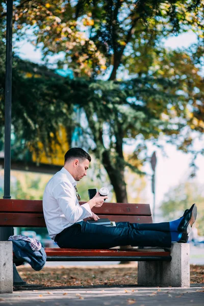 Hombre Negocios Urbano Está Sentado Banco Centro Ciudad Sonriendo Relajándose —  Fotos de Stock