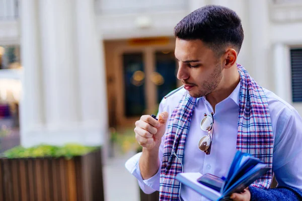 Joven Hombre Negocios Está Fumando Cigarrillo Aire Libre Está Sosteniendo —  Fotos de Stock