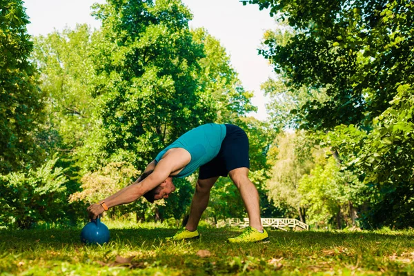 Υγιής Άνθρωπος Κάνει Ανεβάζω Κρατώντας Kettlebell Στο Πάρκο — Φωτογραφία Αρχείου