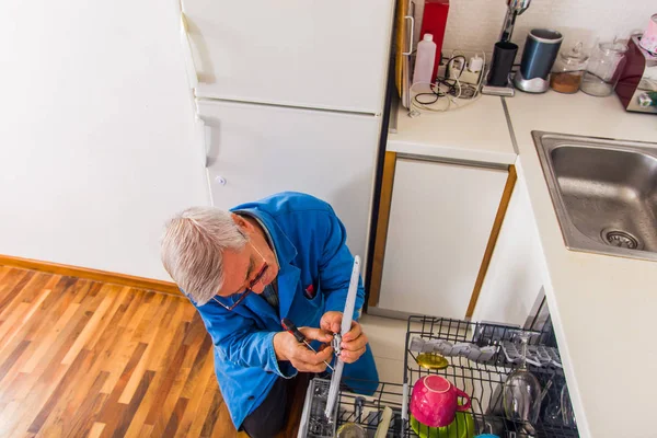 Reparador Terno Trabalho Azul Está Consertando Máquina Lavar Louça Cozinha — Fotografia de Stock