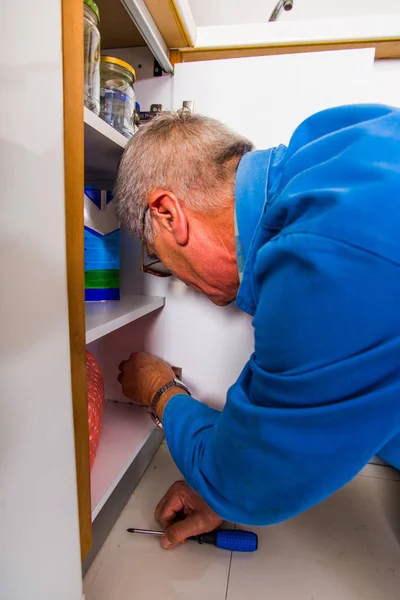 Trabajador Senior Está Fijando Armario Cocina Con Destornillador — Foto de Stock