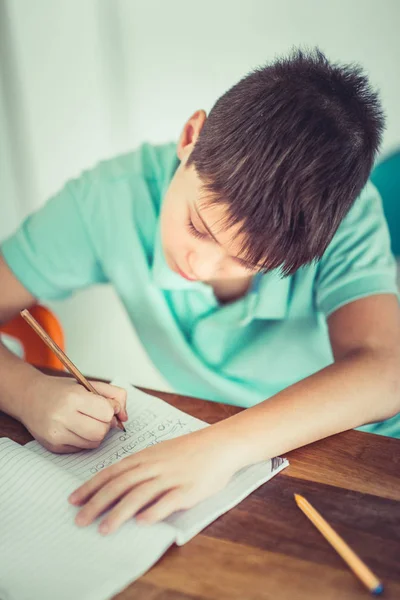 Ein Kind Sitzt Auf Dem Tisch Und Macht Seine Hausaufgaben — Stockfoto