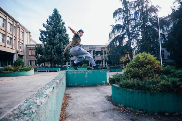 市街地でコンクリート壁を飛び越えるトレーニング パルクールしながらストロングマン — ストック写真