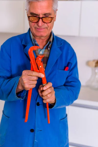 Serious Male Repairman Holding Pilers Working Kitchen — Stock Photo, Image