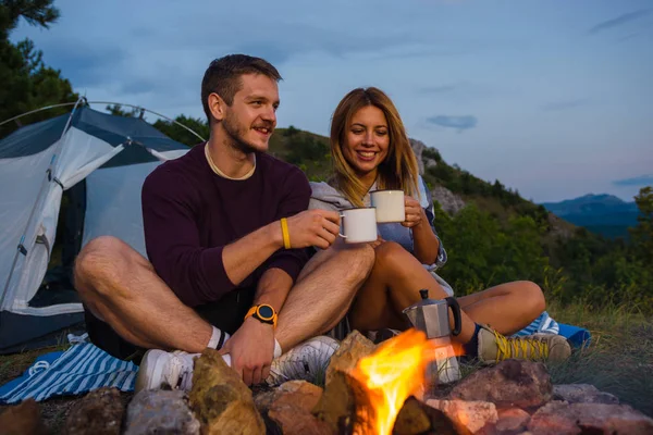 Pareja Joven Tomando Café Calentándose Fogata Atardecer Colina Del Bosque — Foto de Stock