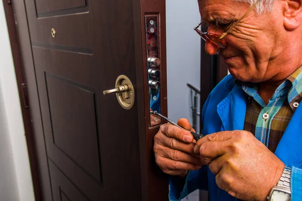 Hombre Servicio Trabaja Manija Puerta Mientras Sostiene Destornillador — Foto de Stock