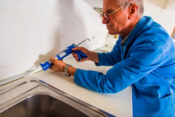 핸디는 Caulking 들고와 부엌에서 — 스톡 사진