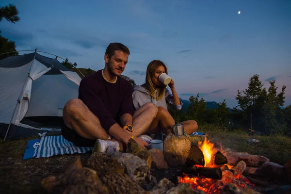 Casal Jovem Desfrutando Fogueira Colina Floresta Entardecer Bebendo Café Aquecendo — Fotografia de Stock