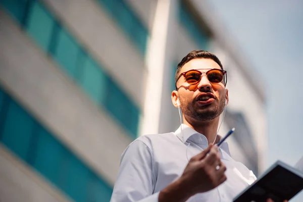 Selbstbewusster Geschäftsmann Steht Mit Aufgesetzten Kopfhörern Der Nachbarschaft Hält Stift — Stockfoto