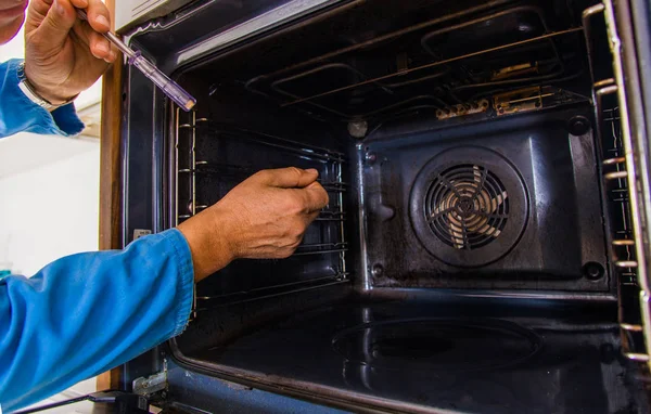 Old Age Repairman Holding Screwdriver Looking Oven — Stock Photo, Image