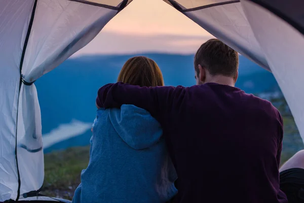 若いカップルを抱き締めると 夕日で山の頂上で山の景色を楽しむ — ストック写真