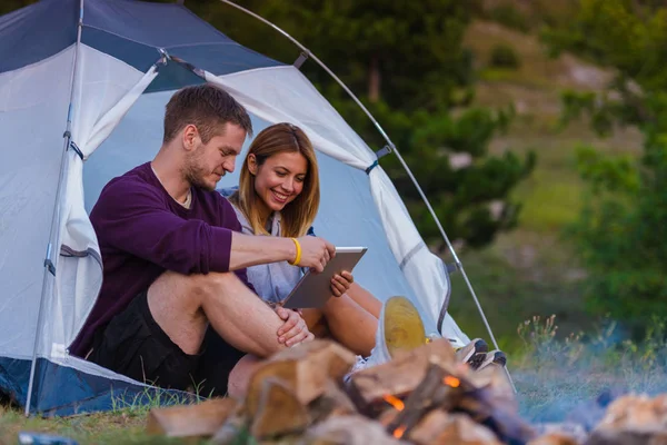 Young Couple Enjoying Mountain View Checking Tablet Bonfire Sunset — Stock Photo, Image