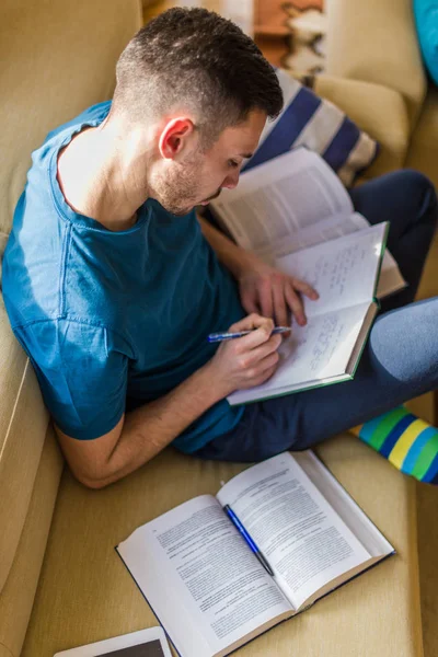 Ein Junger Mann Schaut Interessiert Während Notizen Notizbuch Macht — Stockfoto