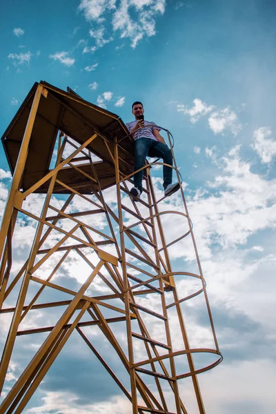 Junger Mann Klettert Auf Metallkonstruktion Und Schaut Von Oben Herab — Stockfoto