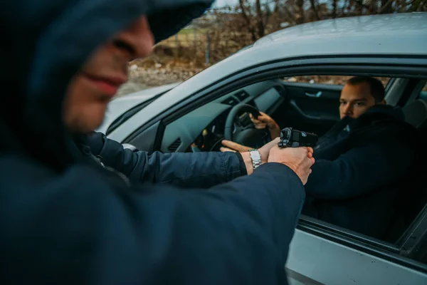 Carjacker greift Autobesitzer aggressiv mit Waffe an und versucht Geld zu erpressen. — Stockbild Carjacker Greift Autobesitzer Aggressiv Mit Waffe Und Versucht Geld Erpressen — Stockfoto