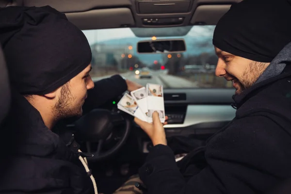 After the successful bank robbery, the thieves are sitting in the car showing off their money and celebrating the win over the law they had.