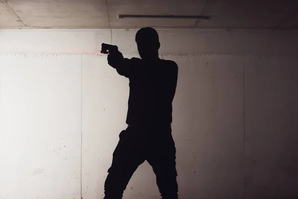 Silueti Silahını Tutan Lazer Işınıyla Hedefi Gösteren Silahlı Bir Adamın — Stok fotoğraf