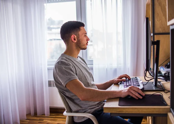 Junger Mann Schaut Auf Computerbildschirm Arbeitet Zimmer — Stockfoto