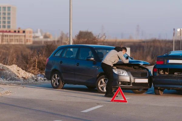 Hombre usando teléfono inteligente en la carretera después de accidente de tráfico — Foto de Stock