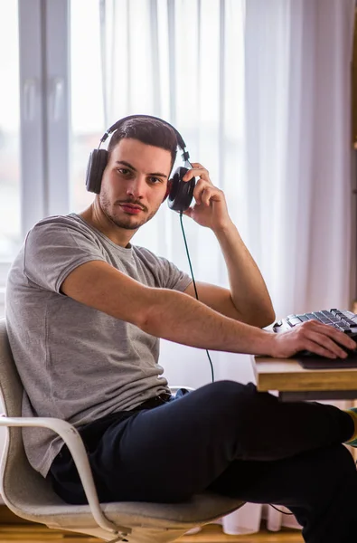 Mann mit Kopfhörern arbeitet am PC — Stockfoto