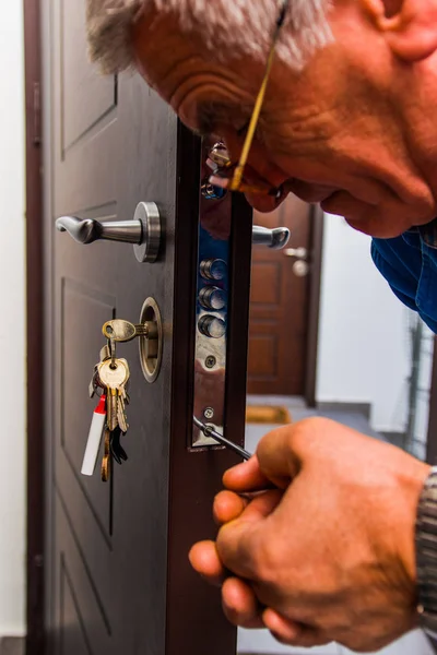Handyman repairs the door In hallway — Stock Photo, Image