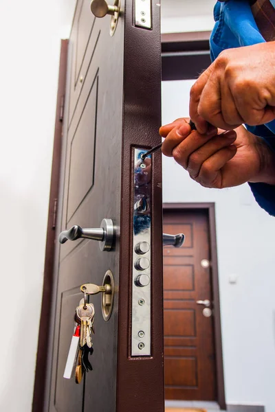 Trabajador arreglando la cerradura de la puerta — Foto de Stock