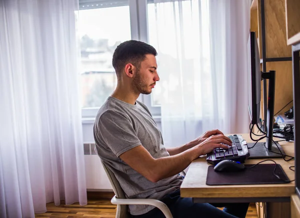 Mann arbeitet von zu Hause aus am Desktop-Computer — Stockfoto