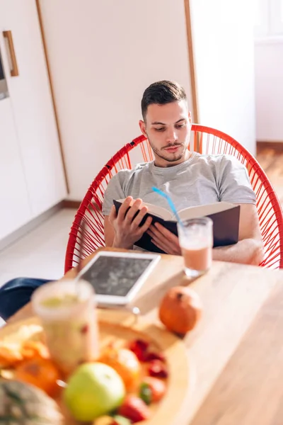 Gesunder starker junger Mann liest frühmorgens ein Buch — Stockfoto