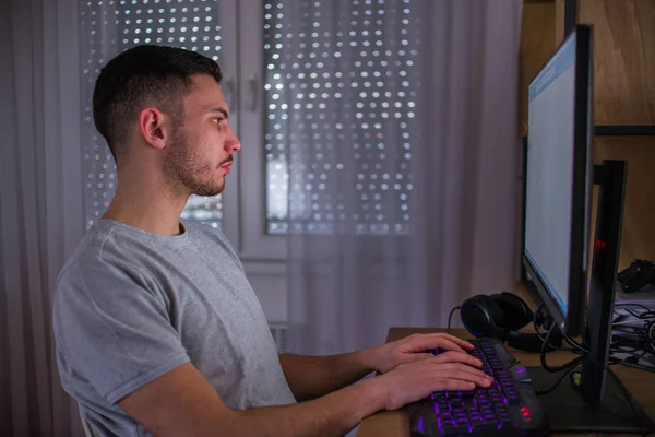 Όμορφος άνθρωπος παίζοντας ένα κομπιούτερ παιχνίδια στο σπίτι — Φωτογραφία Αρχείου