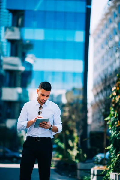 Hombre de negocios con camisa blanca está sonriendo y sosteniendo la tableta . — Foto de Stock