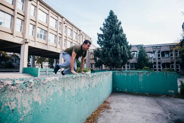 Antrenman yaparken beton duvardan atlayan güçlü bir adam. — Stok fotoğraf