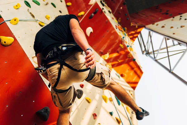 Muscular man descending down on a big wall — Stock Photo, Image