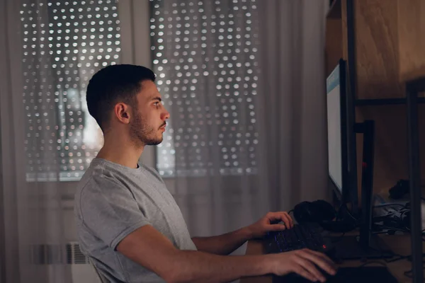 Programador trabajando en su ordenador mientras la luz de la pantalla refleja — Foto de Stock