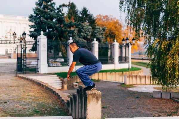 Молодий чоловік у 20-х робить паркур трюк в громадському місці в — стокове фото