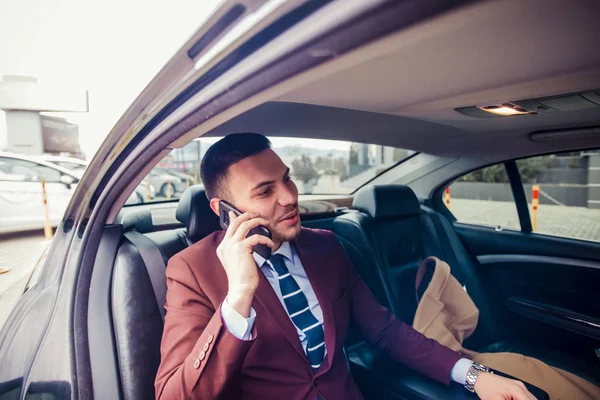 Traje hombre conduciendo en un coche de lujo — Foto de Stock