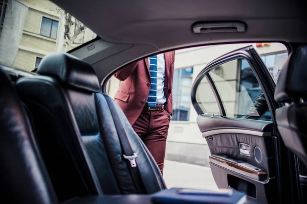 Hombre de negocios rico conduciendo en una limusina y hablando por teléfono — Foto de Stock
