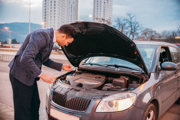 Un trabajador cansado está de pie junto a su coche vestido formalmente y — Foto de Stock