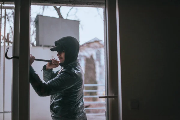 Ladrón tratando de abrir la ventana con la herramienta de palanca — Foto de Stock